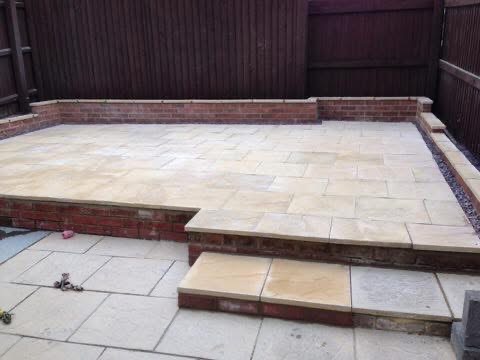 Sandstone patio with brick retaining walls and steps